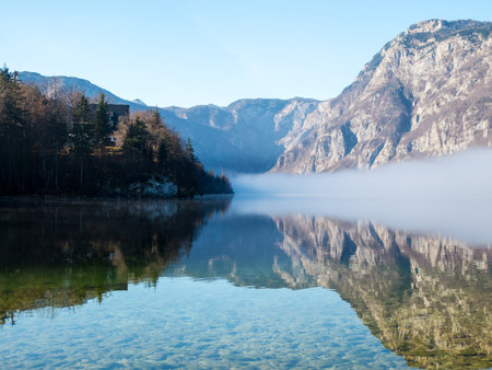 Fog over the lake with mountains in the backgroundの写真素材
