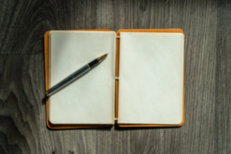 Notebook with blank pages and pencil on wooden table. Open notebook copy space for text high angle view. Taking notes on a notepad concept. Blurry background.の写真素材