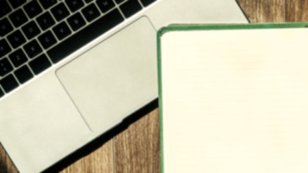 Laptop and notepad with blank pages. Blank note paper and laptop. Office desk concept high angle view. Selective focus includedの写真素材