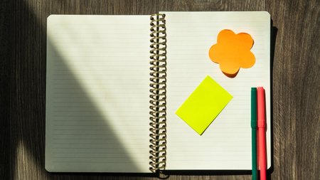 Notepad on a wooden table high angle view. Open notepad with blank paper. Copy space for text....