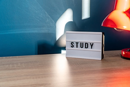 Study background concept. Study room concept. Wooden table or desk with lamp in a home with natural daylight. comfy workplace. Selective focus includedの写真素材