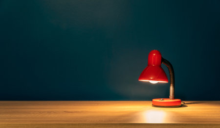 Study concept background. Desk lamp on a wooden table. Work from home concept. Red desk lamp on a...