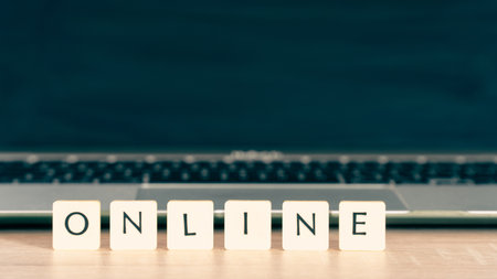 Online shopping concept. Shopping cart or trolley and laptop on wooden table.の写真素材