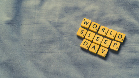 World Sleep Day concept with small lettered stones. Sleeping concept on a soft bed sheet. High angle viewの写真素材