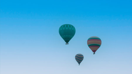 Cappadocia Turkey. Hot air balloons flying over fairy chimneys at sunrise in Cappadocia. Travel to Turkey. Touristic landmarks of Turkiye. Selective focus included.の写真素材