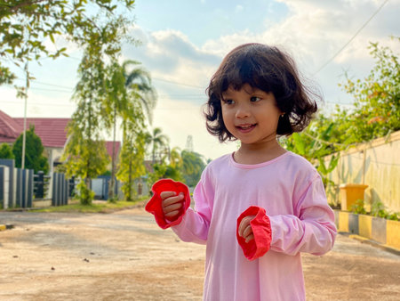 Portrait asian cute kid wearing pink dress standing outdoorの写真素材