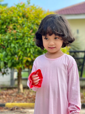Portrait asian cute kid wearing pink dress standing outdoorの写真素材