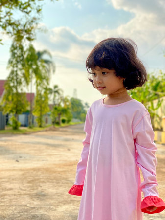 Portrait asian cute kid wearing pink dress standing outdoorの写真素材