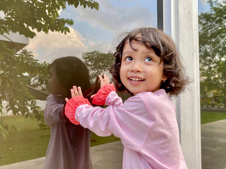 Portrait asian cute kid wearing pink dress standing outdoorの写真素材