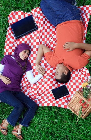Young loving couple having a picnic while holding hands