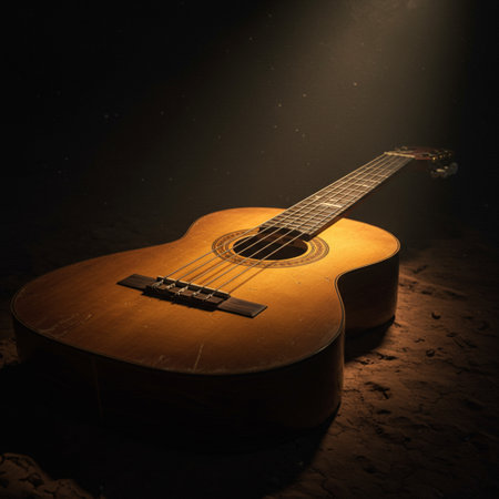 Acoustic guitar on the sand in a dark room with a spotlightの素材