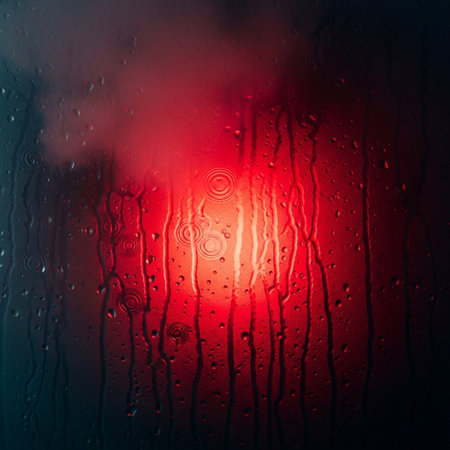 Raindrops on the window with a red background. Close-up.の素材