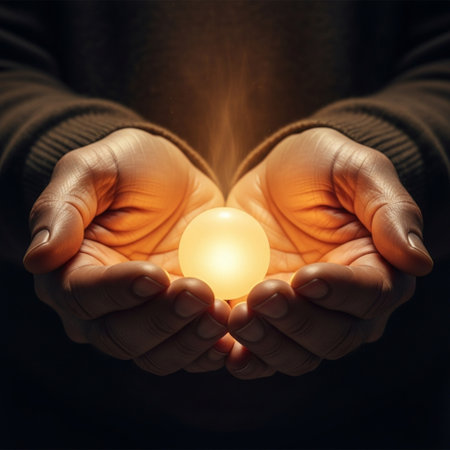 Close up of human hands holding glowing light bulb over dark background.の素材