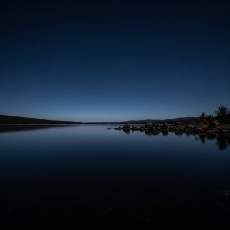 Night landscape with starry sky reflected in the calm water of a lakeの素材