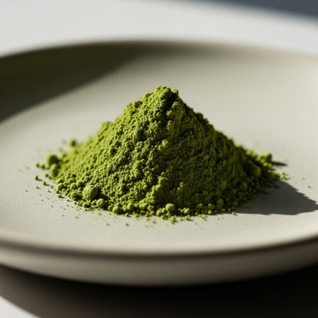 Green matcha powder on a white plate, close-up.の素材