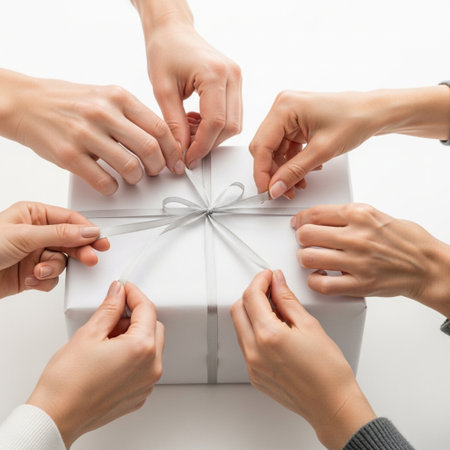Close-up of female hands tying bow on gift box on white backgroundの素材