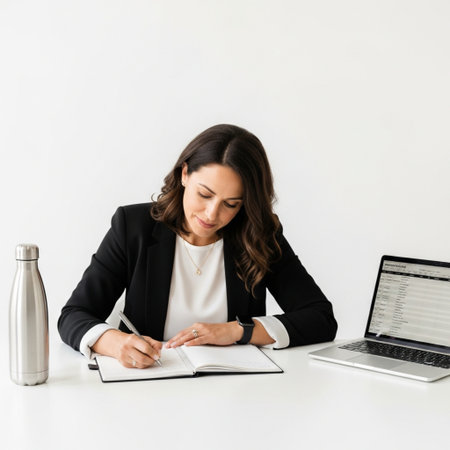 Image of a beautiful young business woman writing in notebook isolated over white wall background.の素材