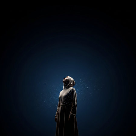 Young woman in dark cloak standing with back and looking at night skyの素材