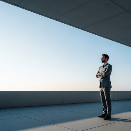 businessman standing with crossed arms and looking at window on roof terraceの素材