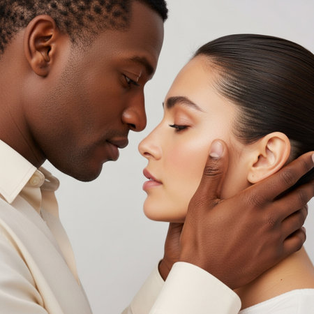 African american man touching face of beautiful woman, isolated on greyの素材