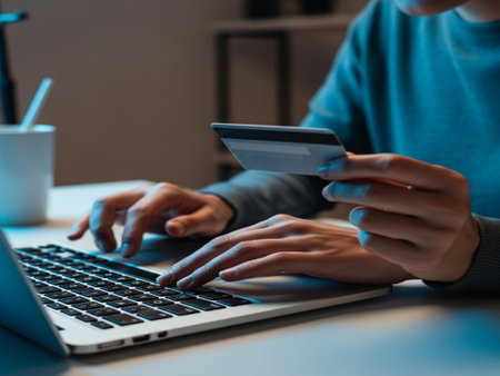Close-up of a woman using laptop and holding a credit cardの素材