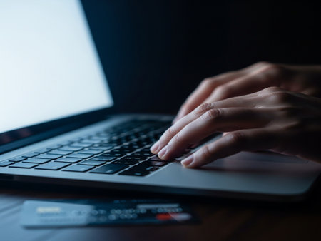 Close-up image of female hands typing on laptop keyboard at nightの素材