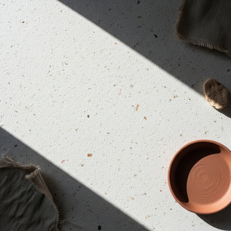 Empty clay pot on white concrete background with shadow from the window.の素材