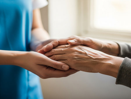 Close up of a doctor holding hands of a senior patient at homeの素材