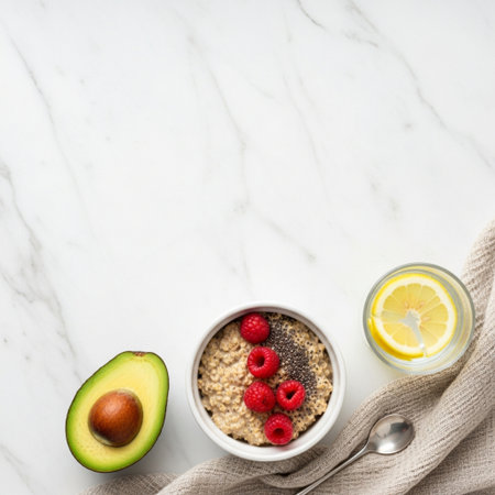 Healthy breakfast. Oatmeal with berries, lemon and avocado on white marble background, top view, copy spaceの素材