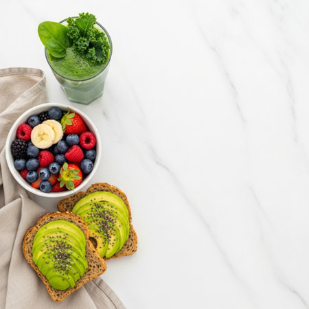 Healthy breakfast with green smoothie and fruits on white marble backgroundの素材