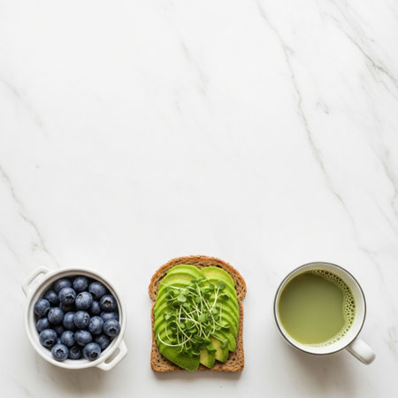 Healthy breakfast - toast with avocado, blueberry and matcha tea on white marble backgroundの素材