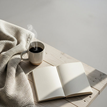 Cup of coffee and book on wooden table with warm wool blanketの素材