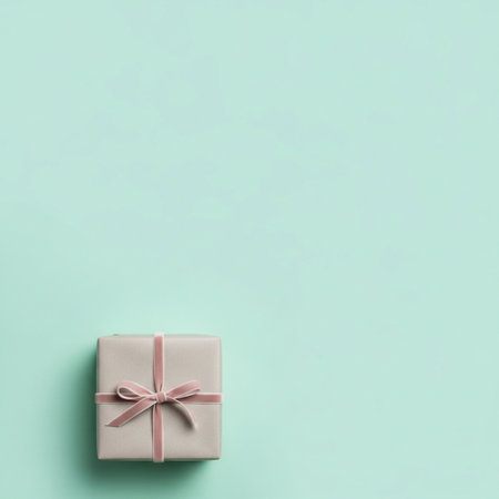 Gift box with pink bow on turquoise background. Flat lay, top view.の素材