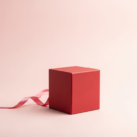 Red gift box with ribbon on pink background. Minimal style.の素材