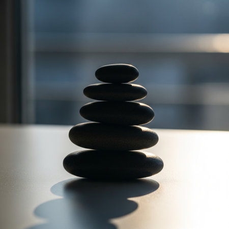 Stack of black pebble stones on a table. Zen concept.の素材