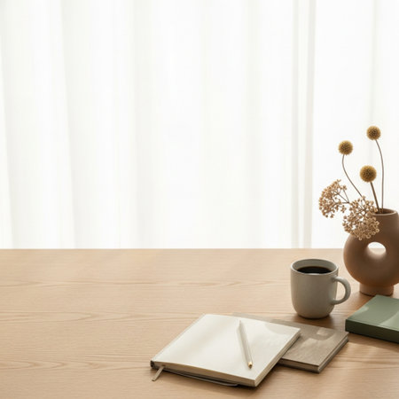 Blank notebook and coffee cup on wooden table with window background.の素材