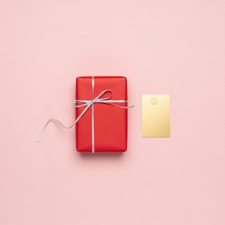 Top view of red gift box and credit card on pink background.の素材