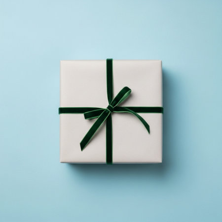 White gift box with green bow on blue background. Flat lay, top view.の素材