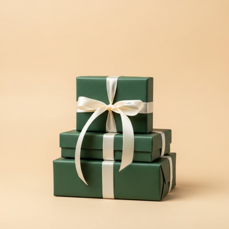 Green gift boxes with ribbon on beige background.  Copy space.の素材