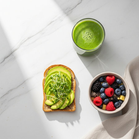 Healthy breakfast with avocado, berries and smoothie on white marble backgroundの素材