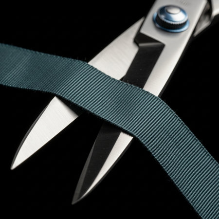 Scissors with blue ribbon on a black background. Shallow dof.の素材