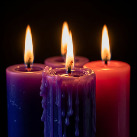 Three burning candles on a black background. Shallow depth of field.の素材