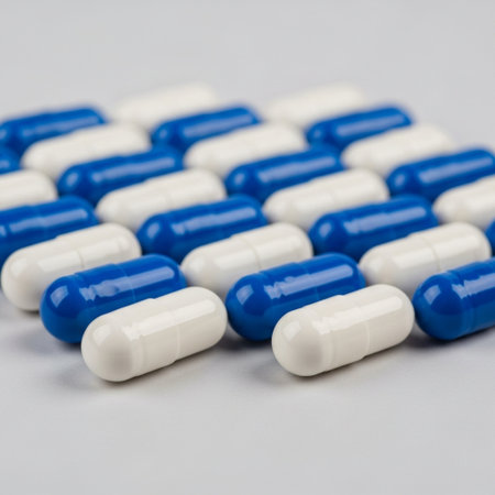 Blue and white capsules on white background. Focus on foreground, soft bokeh.の素材