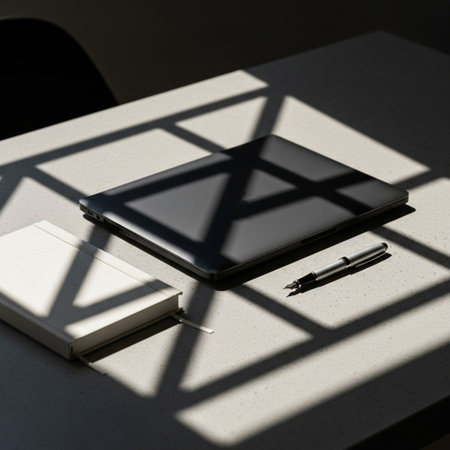 Notebook and pen on a table with shadow from the window.の素材