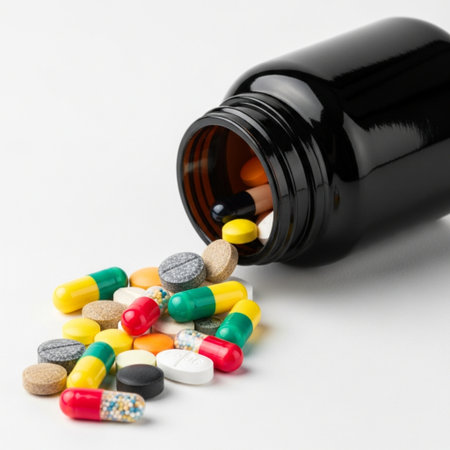 Pills spilling out of pill bottle on white background. Focus on foreground, soft bokeh.の素材