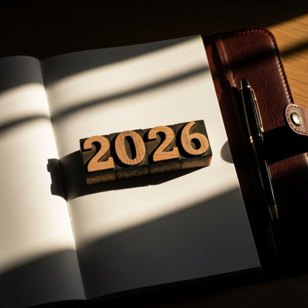 Wooden block number 2016 on notebook with pen on wooden table.の素材