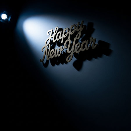 Happy New Year text on a dark background with a glowing spotlightsの素材