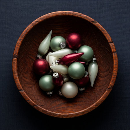 Christmas baubles in wooden bowl on dark blue background, top viewの素材