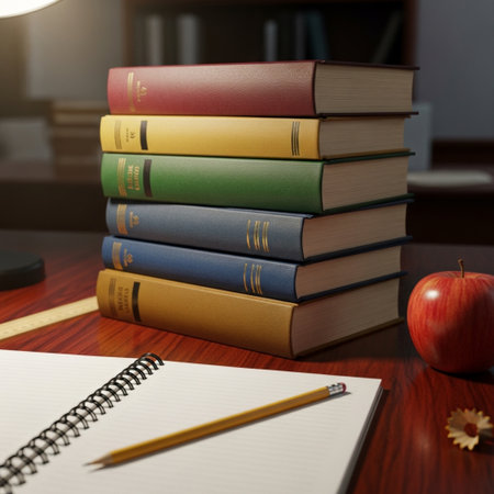 Stack of books on a desk with a pencil and an apple.の素材