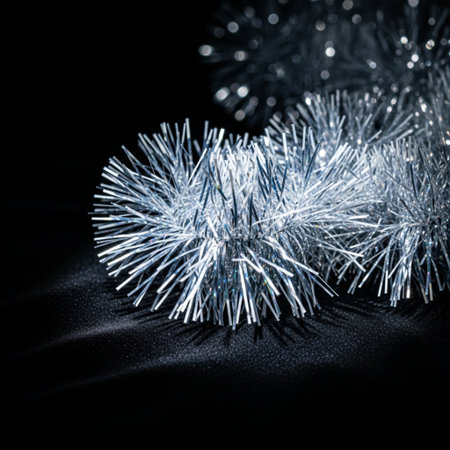 Silver tinsel on black background. New Year and Christmas decoration.の素材